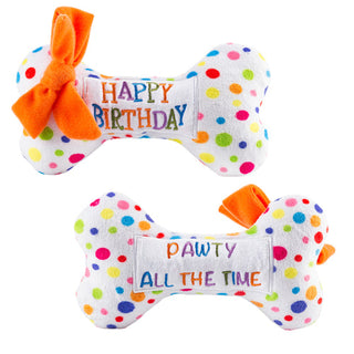 A plush bone shaped dog toy decorated for a birthday celebration